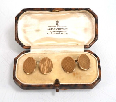 Lot 833 - A pair of 9ct yellow gold oval engine turned...