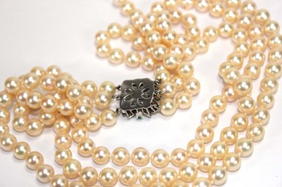 Lot 508 - A triple strand cultured pearl necklace with a...