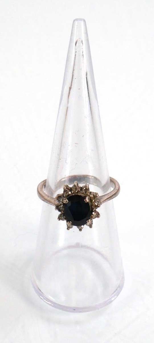 Lot 522 - A white metal ring set oval sapphire within a...