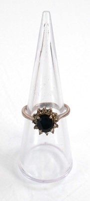 Lot 522 - A white metal ring set oval sapphire within a...