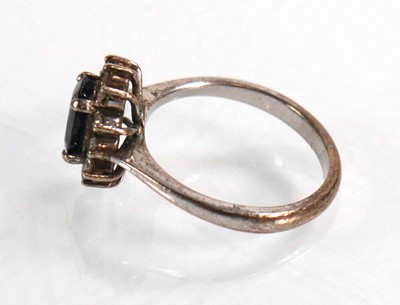 Lot 522 - A white metal ring set oval sapphire within a...
