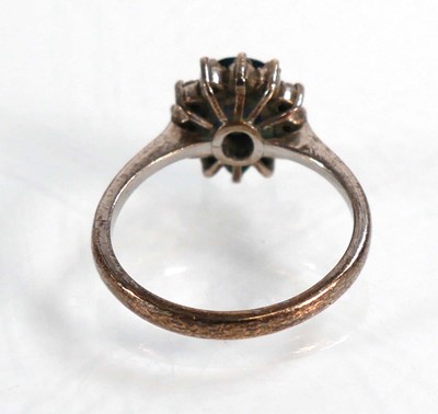 Lot 522 - A white metal ring set oval sapphire within a...