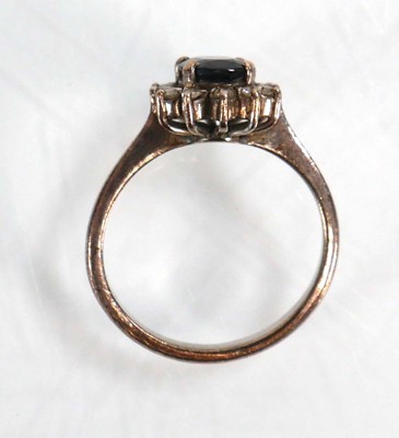 Lot 522 - A white metal ring set oval sapphire within a...