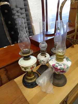 Lot 5360 - Four floral patterned and brass oil lamps