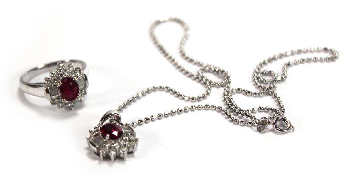 Lot 546 - An 18ct white gold cluster ring set oval ruby...