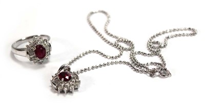 Lot 546 - An 18ct white gold cluster ring set oval ruby...