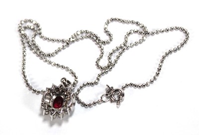 Lot 546 - An 18ct white gold cluster ring set oval ruby...