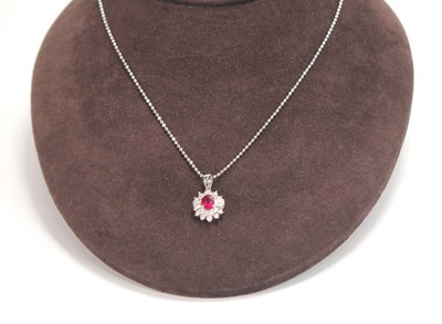 Lot 546 - An 18ct white gold cluster ring set oval ruby...