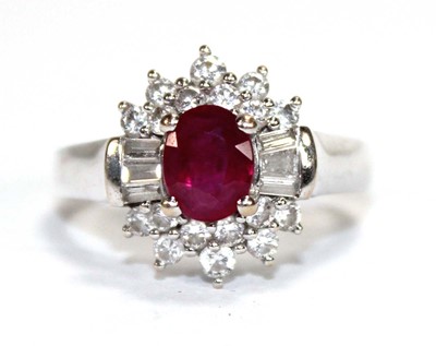 Lot 546 - An 18ct white gold cluster ring set oval ruby...