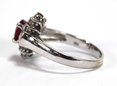Lot 546 - An 18ct white gold cluster ring set oval ruby...