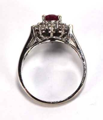 Lot 546 - An 18ct white gold cluster ring set oval ruby...