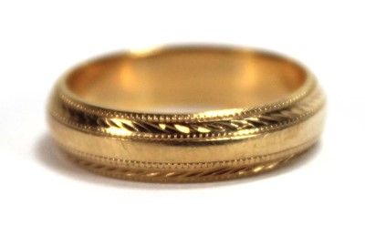 Lot 557 - An 18ct yellow gold wedding band with beaded...