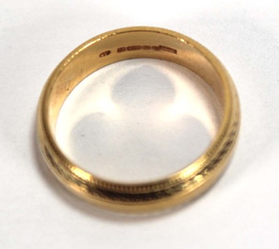 Lot 557 - An 18ct yellow gold wedding band with beaded...