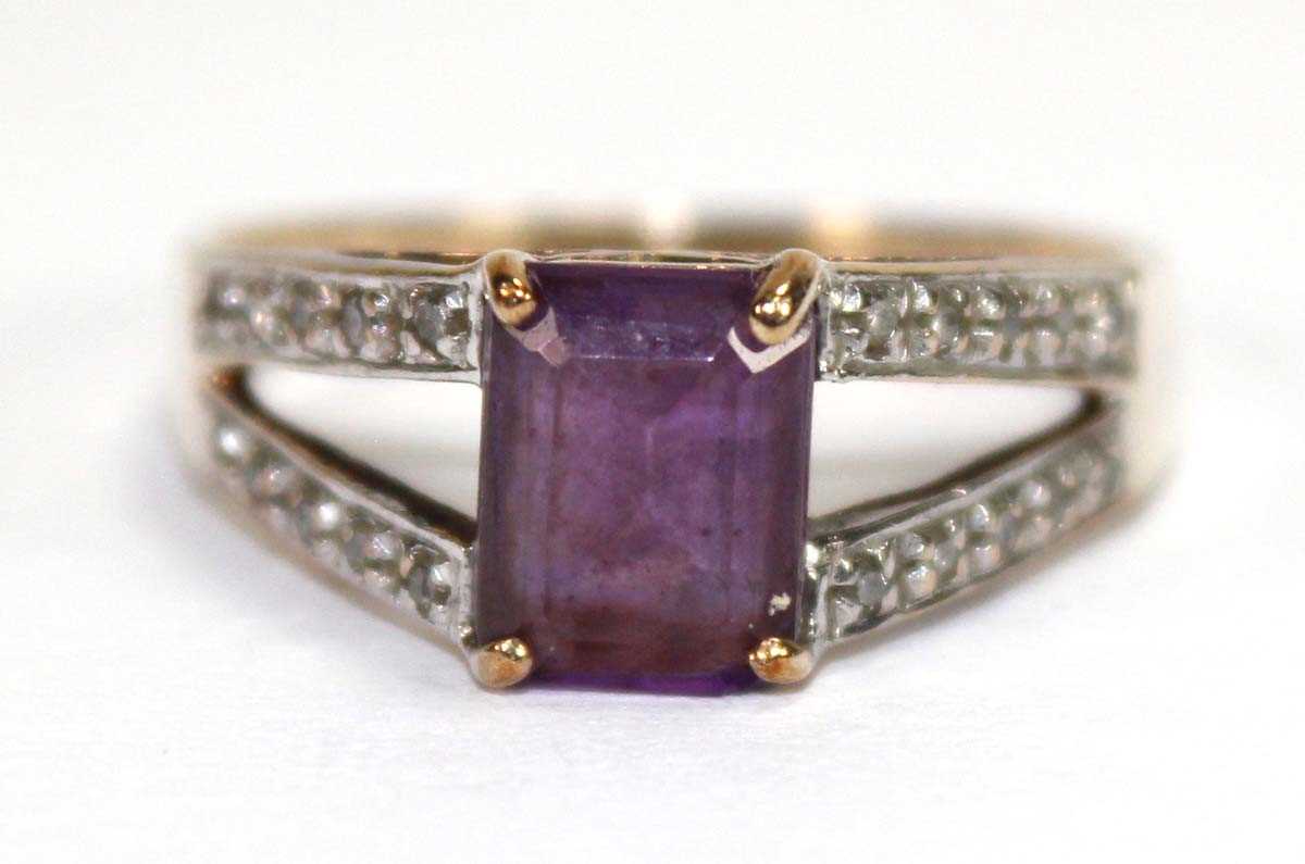 Lot 559 - A 9ct yellow gold ring set oval purple stone...