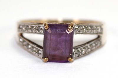 Lot 559 - A 9ct yellow gold ring set oval purple stone...