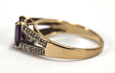 Lot 559 - A 9ct yellow gold ring set oval purple stone...