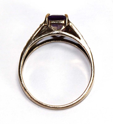 Lot 559 - A 9ct yellow gold ring set oval purple stone...