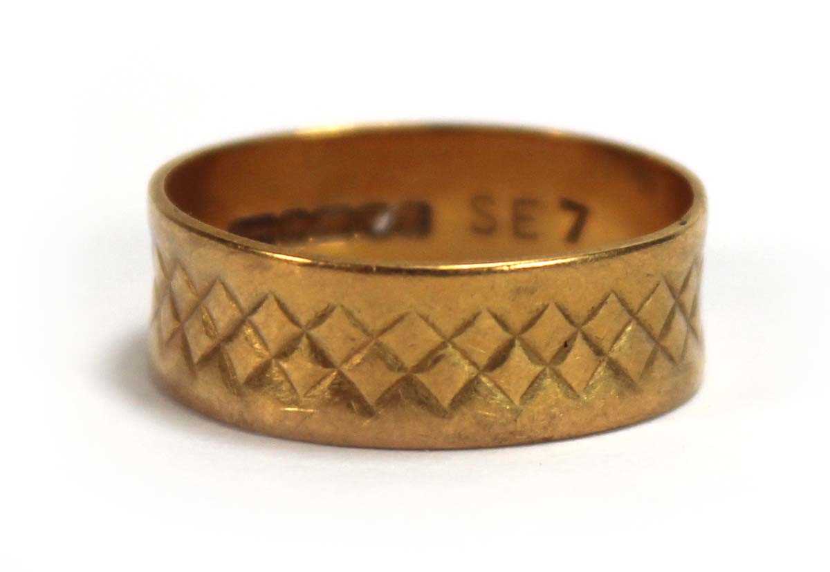 Lot 567 - A 22ct yellow gold engraved wedding band,...
