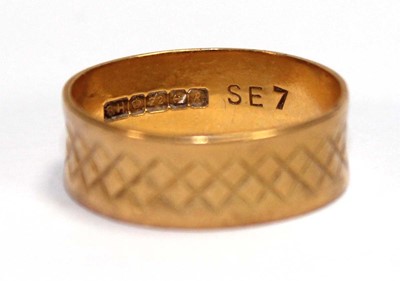 Lot 567 - A 22ct yellow gold engraved wedding band,...