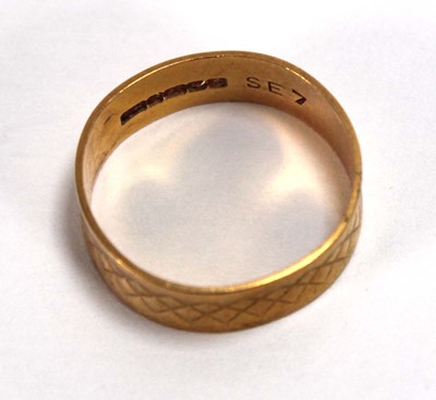 Lot 567 - A 22ct yellow gold engraved wedding band,...