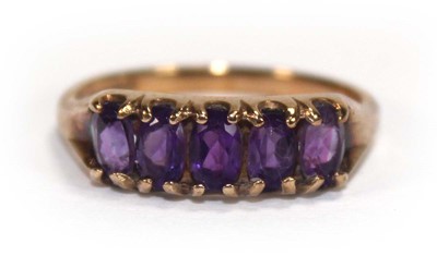 Lot 592 - A 9ct yellow gold ring set five oval amethyst,...