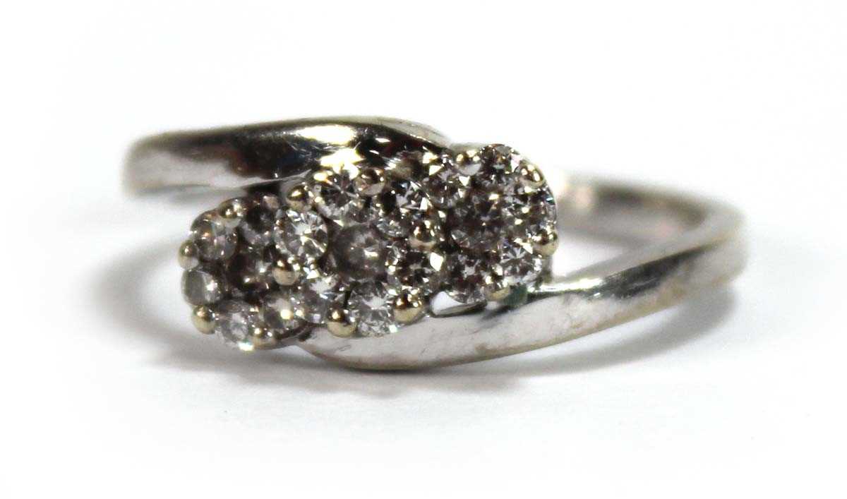 Lot 595 - A 9ct white gold crossover ring set three...