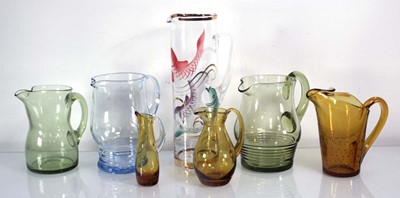 Lot 270 - A group of seven various glass jugs in amber,...