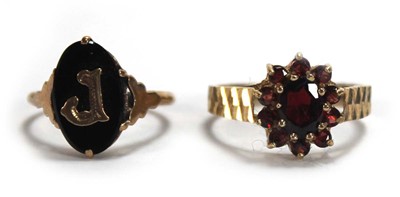 Lot 663 - A 9ct yellow gold cluster ring set garnet,...