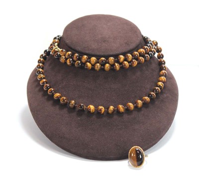 Lot 665 - A single strand tiger's eye necklace, l. 110...