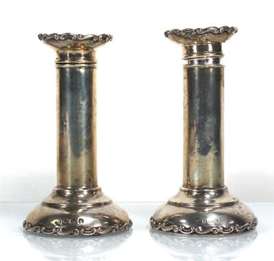 Lot 384 - A pair of Edwardian silver candlesticks of...