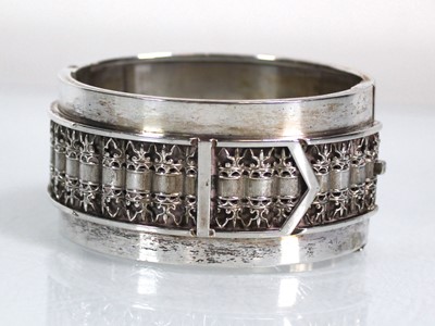 Lot 412 - A silver hinged bracelet with filigree buckle...