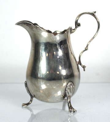 Lot 418 - A silver cream jug with c-scroll handle on...