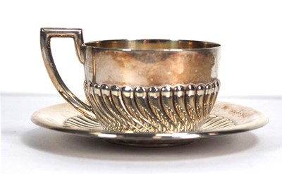Lot 336 - A metalware tea cup and saucer with gadrooned...