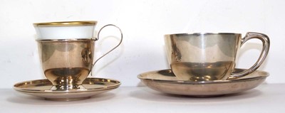 Lot 337 - A metalware tea cup and saucer of plain form,...