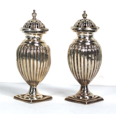 Lot 341 - A pair of late Victorian silver peppers of urn...