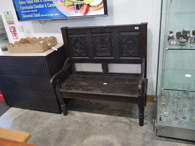 Lot 1304 - Dark oak carved monk's bench bearing the...