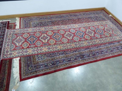 Lot 5046 - Persian style carpet runner with red ground...
