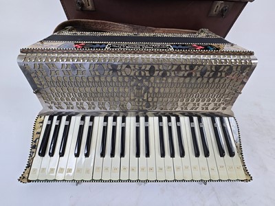 Lot A tan leather cased piano accordion with...