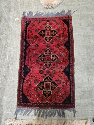 Lot 104 - A small eastern hand woven wool rug with...